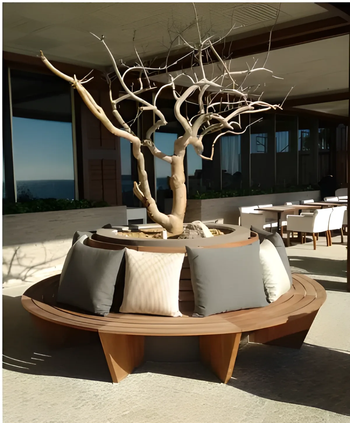 Circular wood bench around tree in hotel courtyard