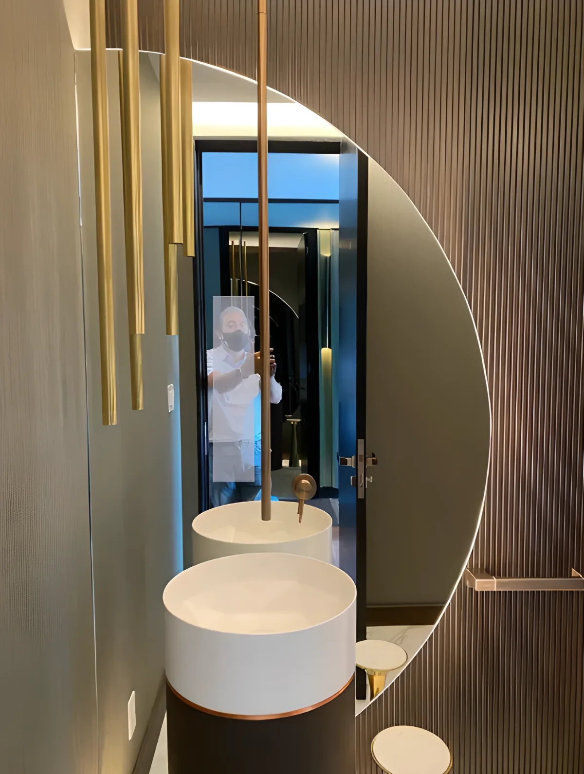 Design semicircular mirror over fluted paneling and pedestal sink, luxury bathroom interior design