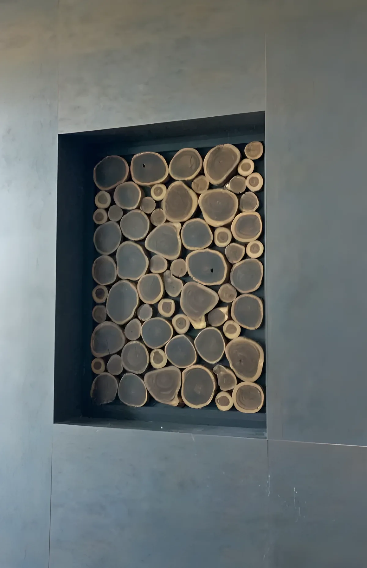 Decorative wall with natural wood slices on anthracite background