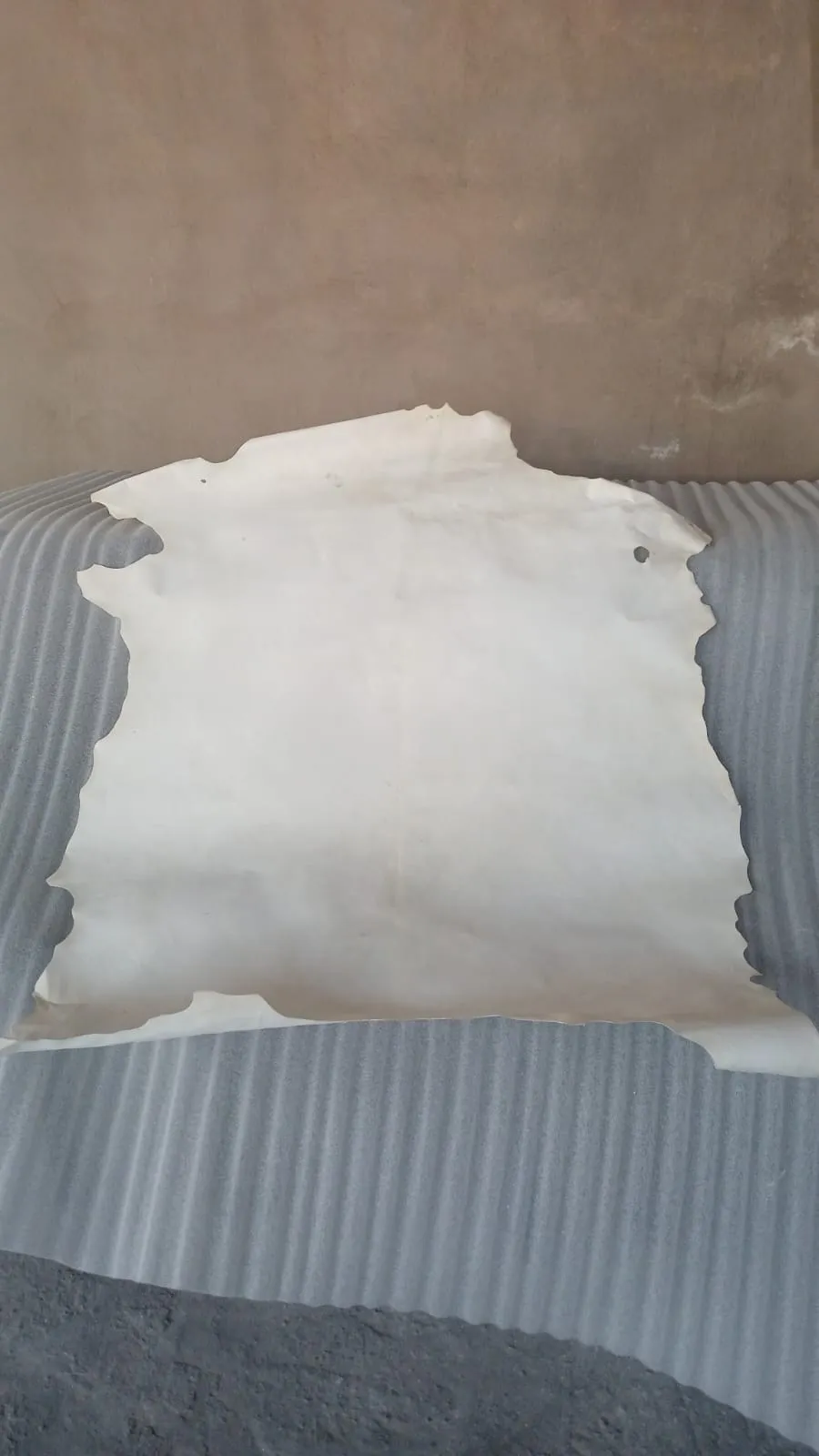 Manual application process of goat skin on coffee table in workshop