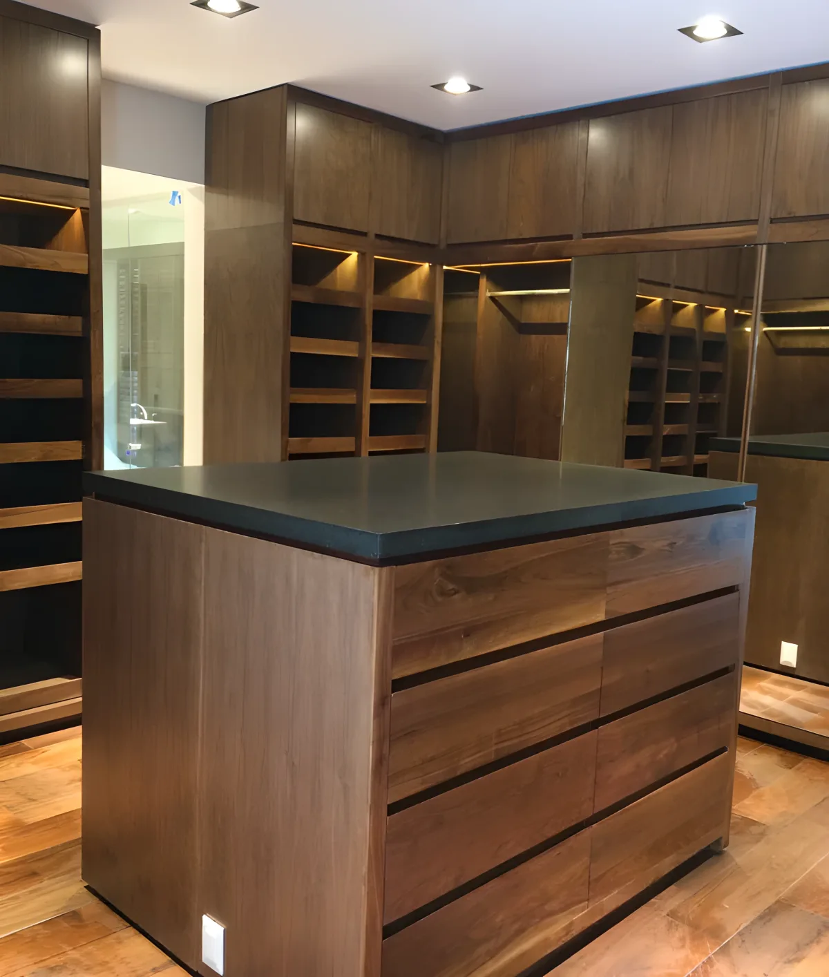Luxury walnut walk-in closet with central island and black stone